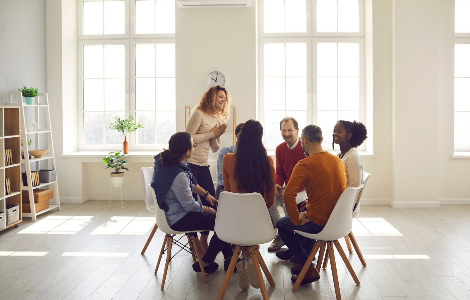 A facilitator and participants seated in a circle during a training session